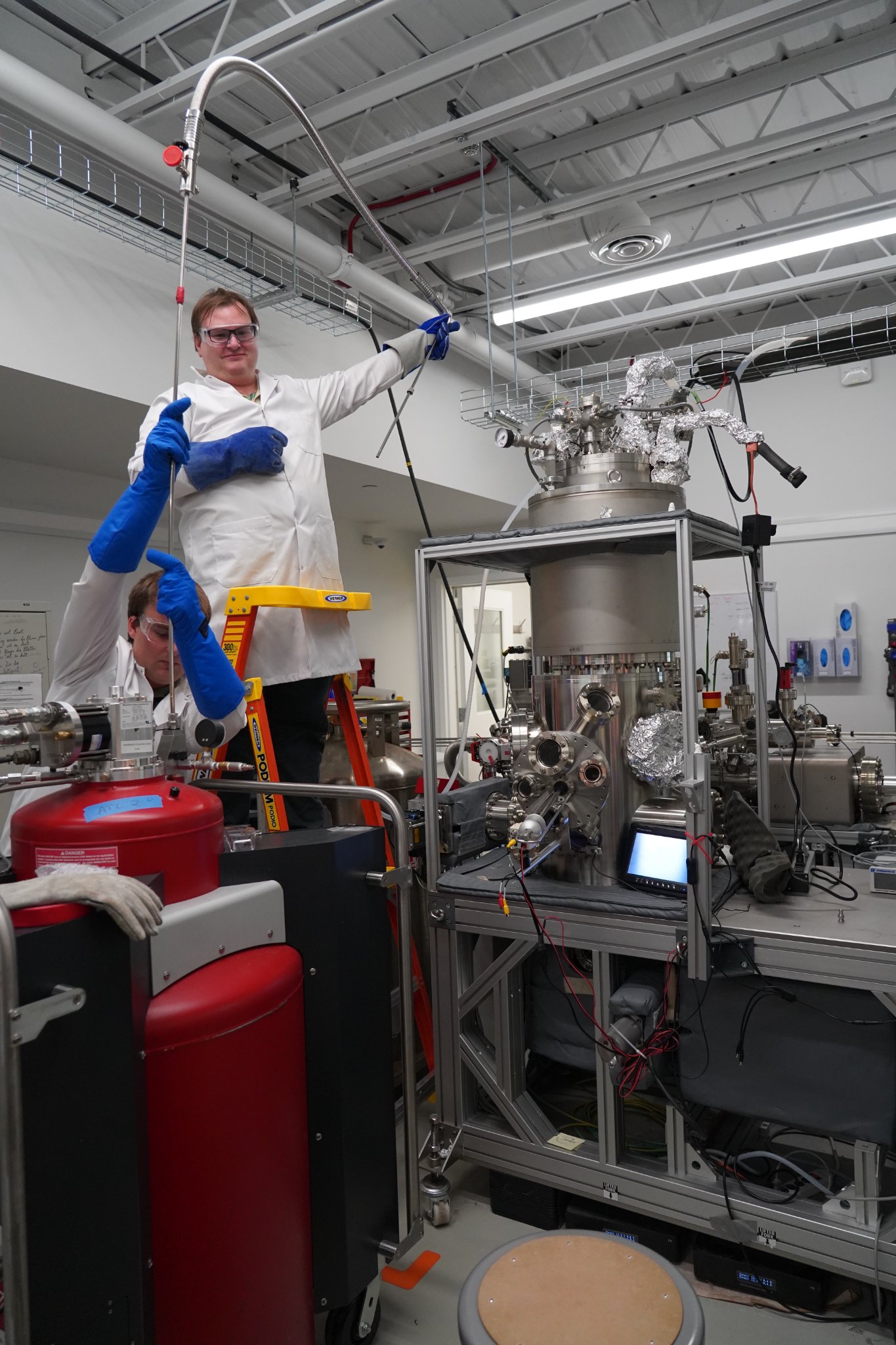 CBN Nano scientists filling a cryostat during routine operation of a molecular workstation